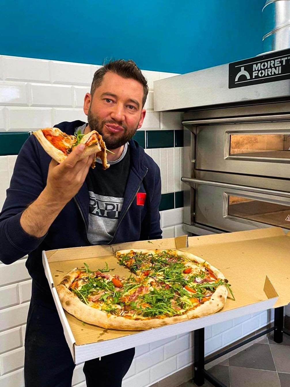 Łukasz Ancypo jedzący pizzę
