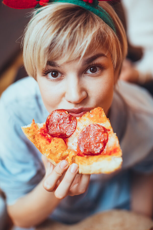 młoda kobieta jedząca pizzę 